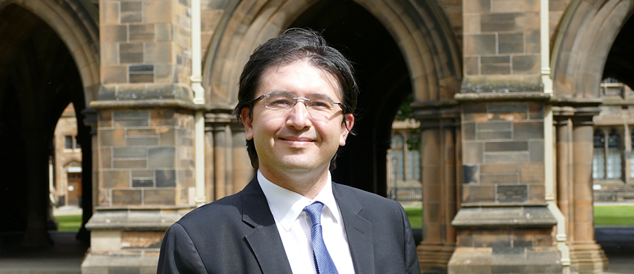 Dr Yusuf Soner Baskaya standing in the Cloisters at the University of Glasgow for a profile photo