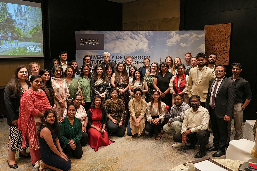UofG delegates and agents in India gathered for a group photo in front of a UofG banner