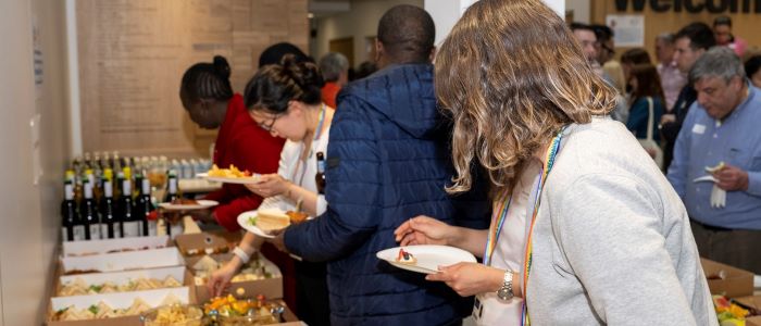 A group of staff select food from a table at the SHW spring fling 2023