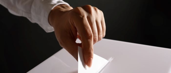 Photo of hand and ballot or suggestions box