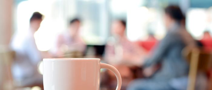 Photo of meeting room with coffee in foreground