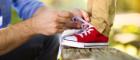 Photo of father helping child tie shoelaces