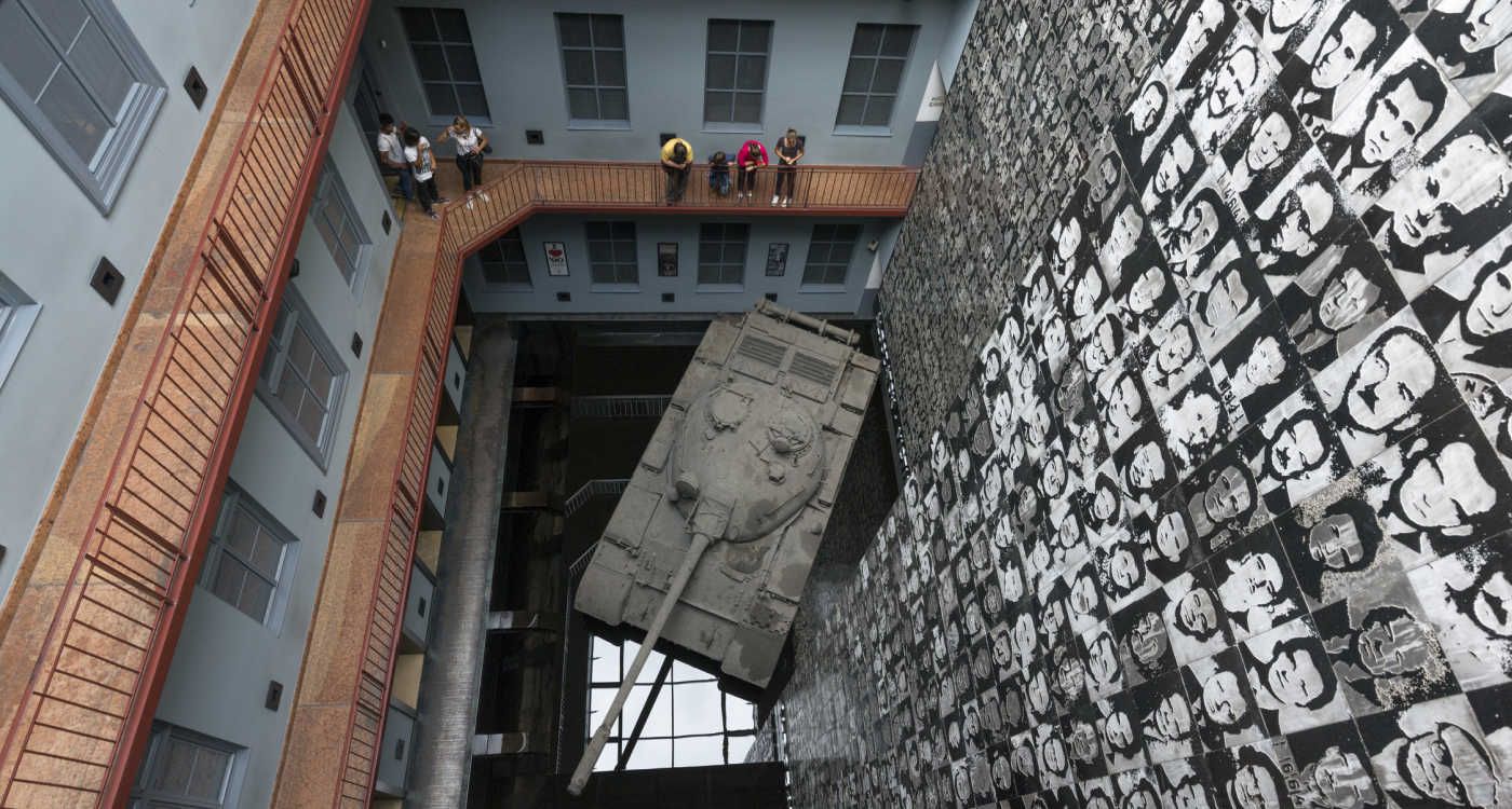 Interior of the House of Terror Museum showing a tank and memorial photos of those killed during bloody periods in Hungarian history [Photo: Shutterstock]