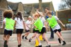 A group of children being active in a school playground.