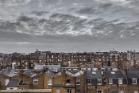 Rooftop view of old houses in London with grey sky and clouds. 700 pixels