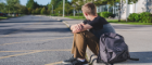 Boy sits on kerb