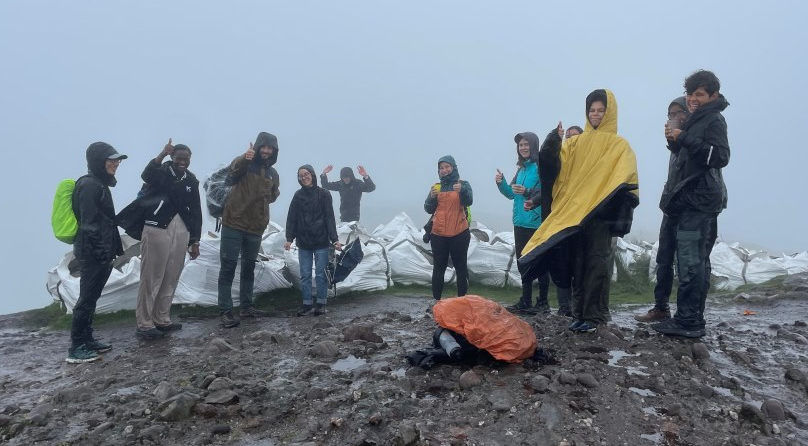 Participants from the summer school stood together at the top of Conic Hill on a wet and windy day