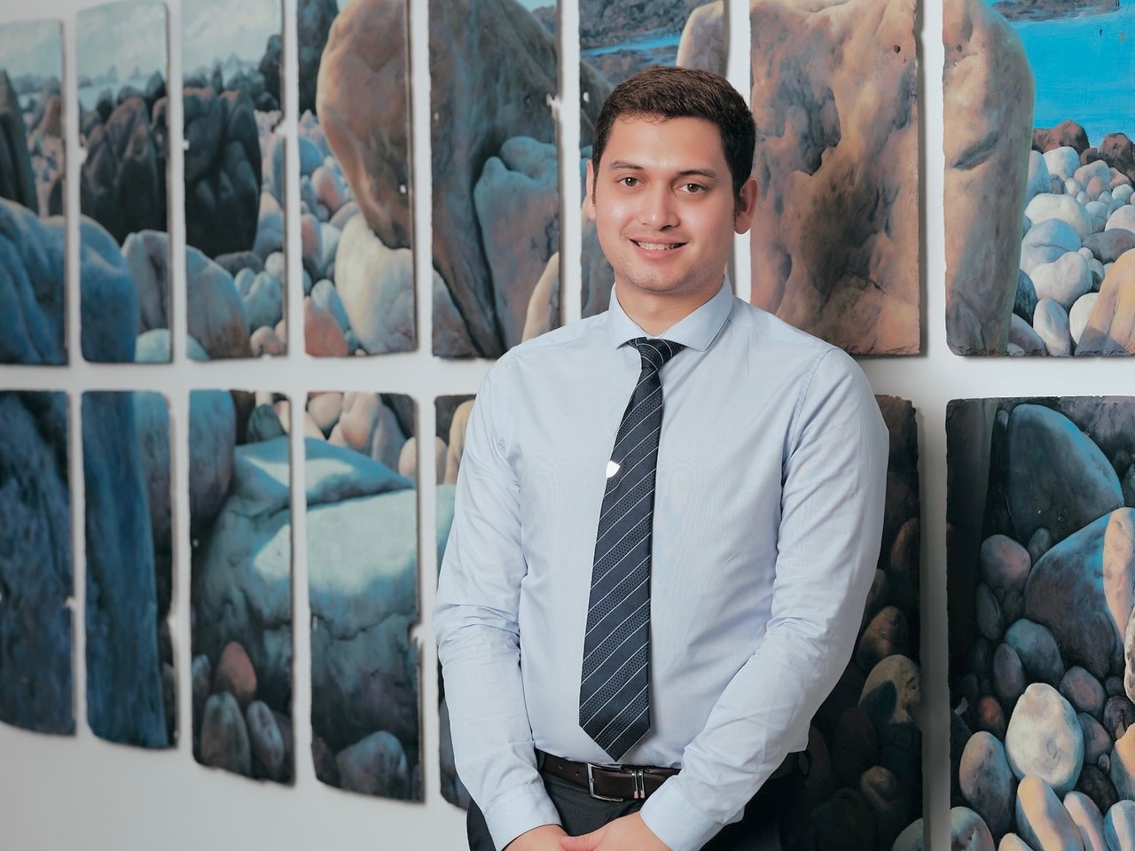 A doctoral researcher's standing Infront of backdrop of Jersey, Channel Islands