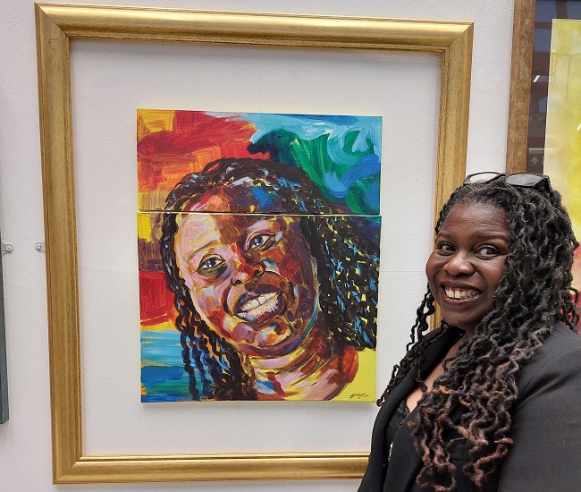 An image of Peggy Brunache and her portrait part of the 100 Black Women Who Have Made A Mark  exhibition