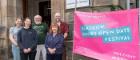 Image of SBOHVM Researchers outside of the Graham Kerr Building standing next to a doors open day banner