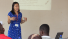 Professor Antonia Ho presenting to a crowd sitting outside during a visit to Africa