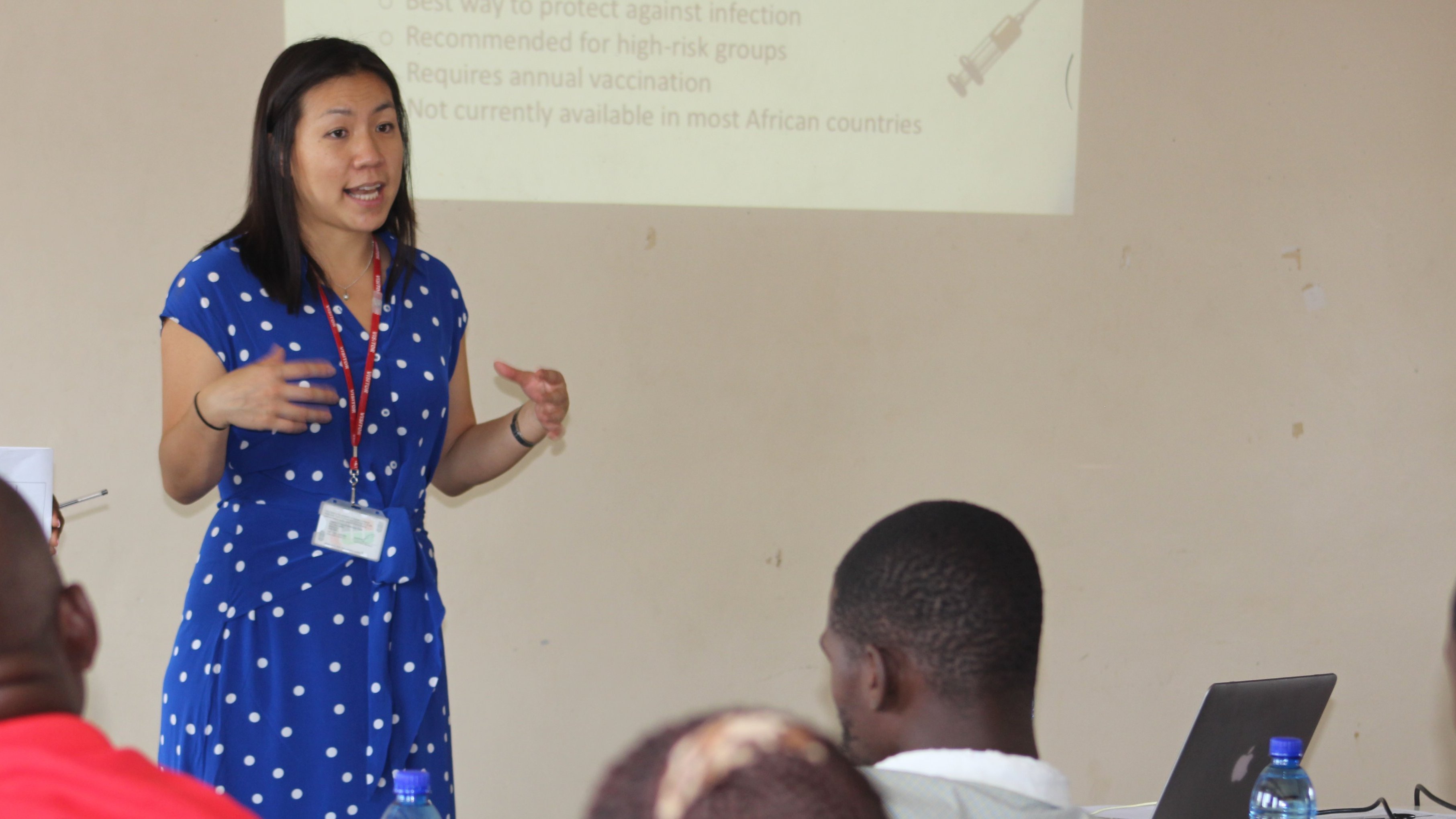 Professor Antonia Ho presenting to a crowd sitting outside during a visit to Africa