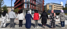  A group of people holding hands outside the Clarice Pears building