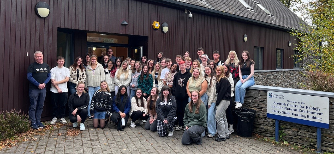 Level 3 Immunology students and Sii staff stood (and crouching) together in a group shout in front of the SCENE facility building