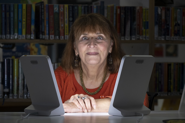 Wintering Well box user Claire Charlwood is pictured with a SAD lamp in Kirkintilloch’s William Patrick library