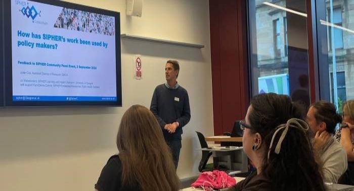 Attendees facing presenter - Julian Cox  and screen showing SIPHER logo and text