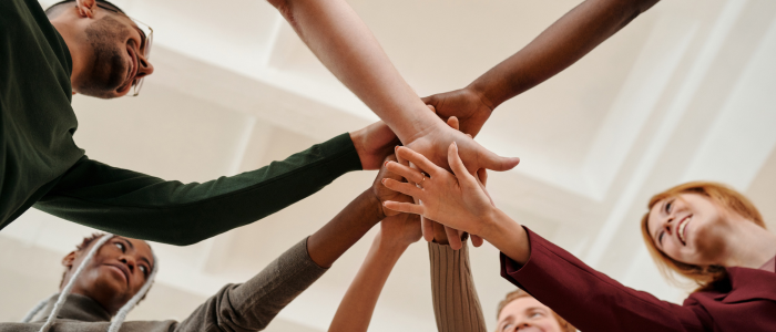 Group of multiracial people joining hands together