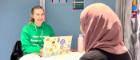 Peer career support student sitting at a desk with another student helping them with career/job questions