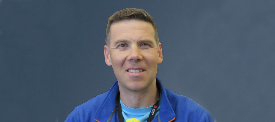 A head and shoulders shot of Professor Andy Roe against a blue background