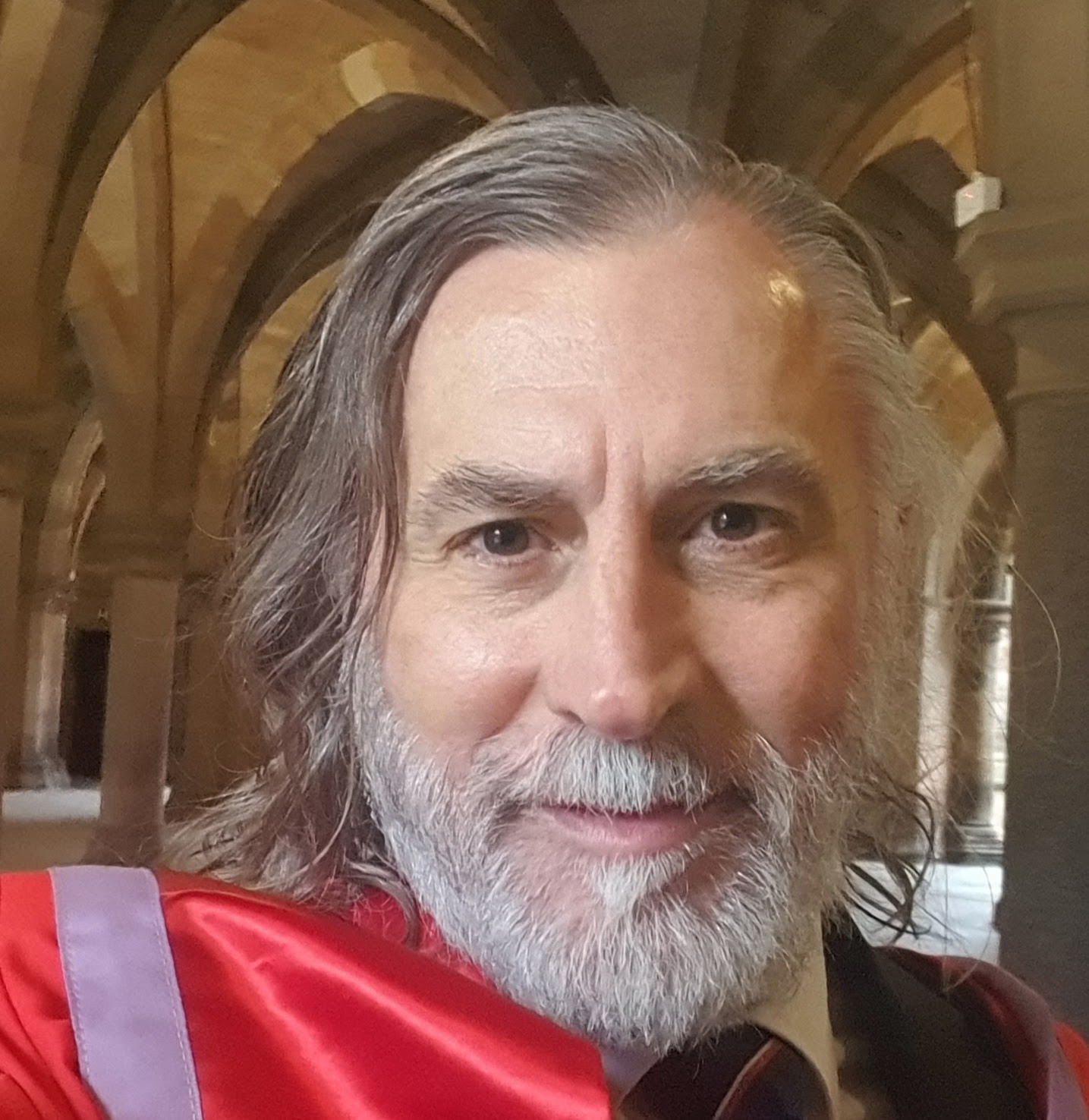 Man in academic dress in Glasgow cloisters