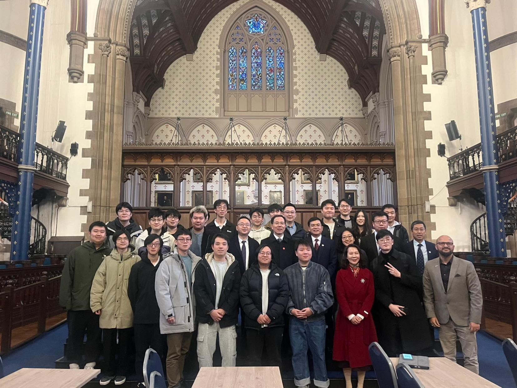 Students standing for a picture with President Hu Jun and colleagues in the Bute Hall