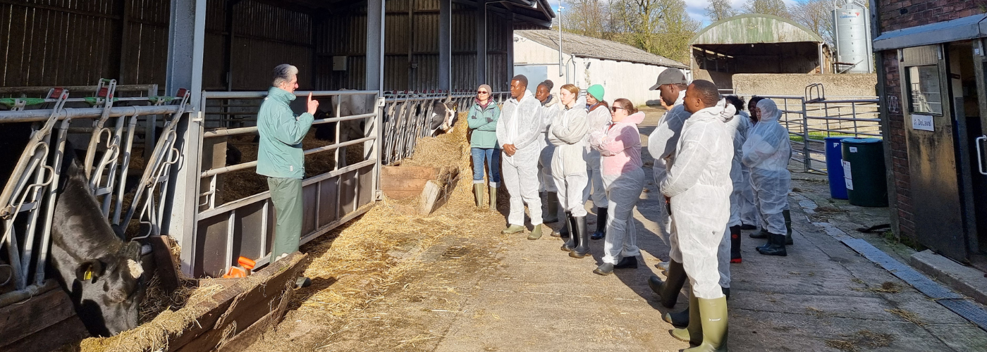 Students listening to man in a farm setting