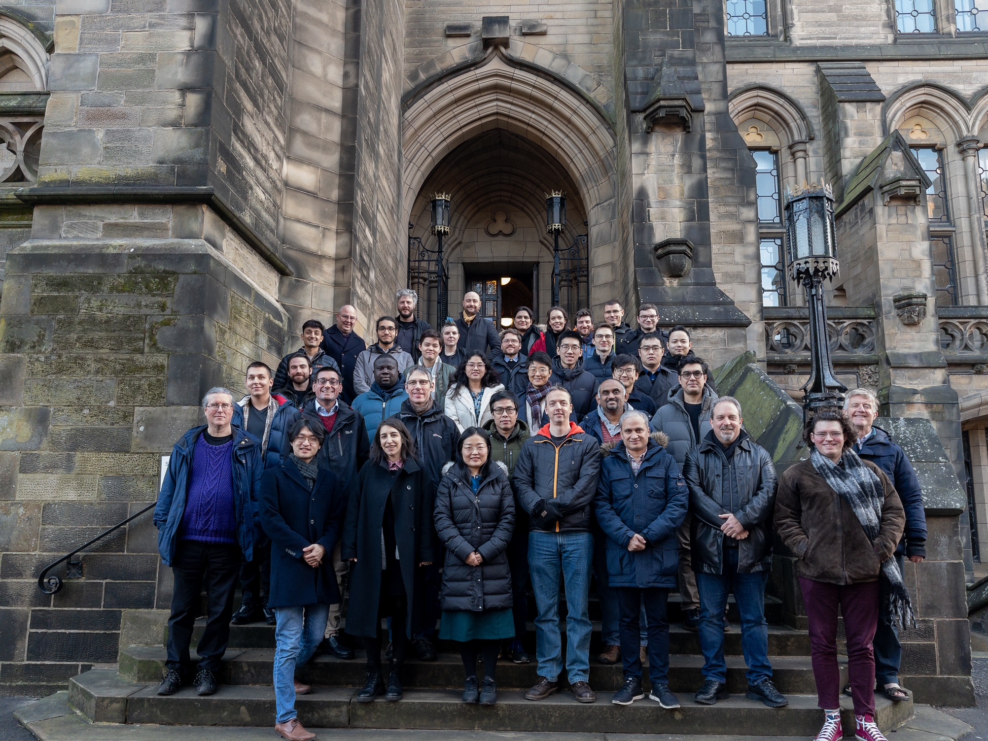 Members of the Glasgow Systems Section standing on the stairs of the UofG main building