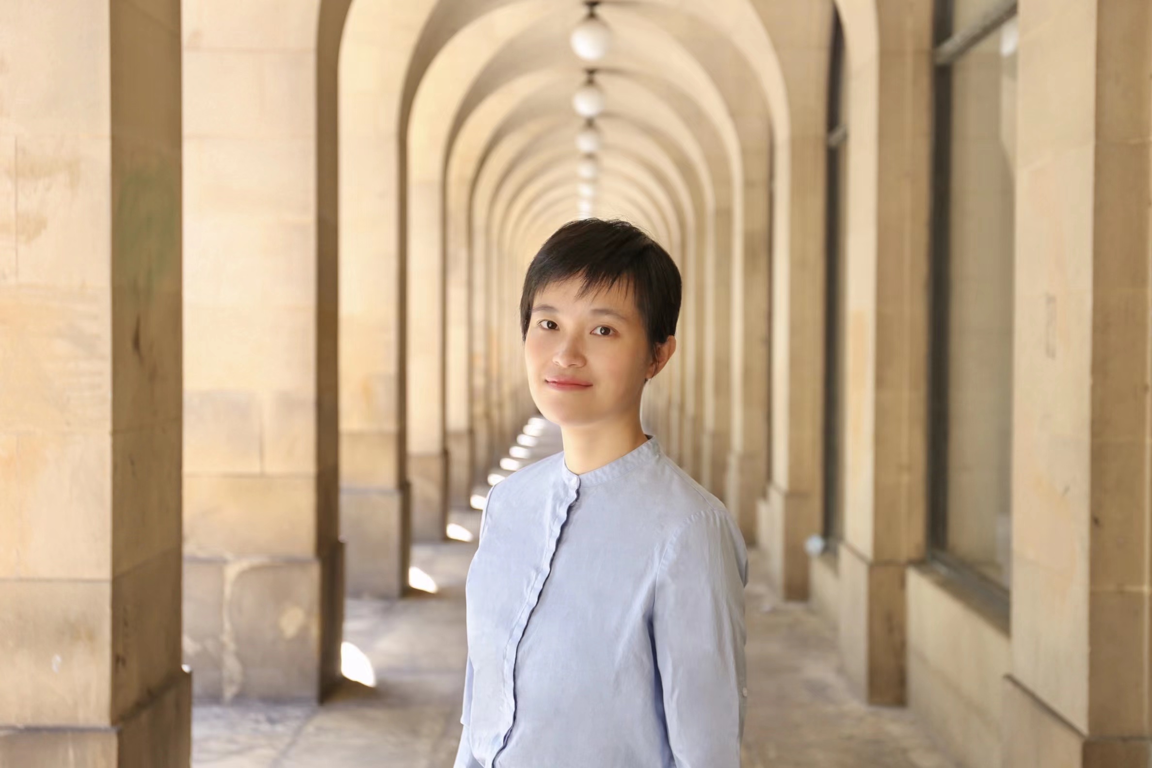 Dr Diansha Wang, Lecturer in HRM Organisational Behaviour (Management), profile photo in front of arches