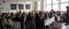 A room full of people, some holding musical instruments, sat on chairs in a circle at the UNESCO RILA Spring School 2019