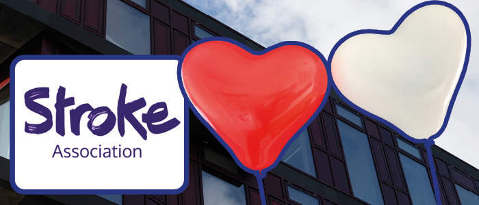 The Stroke Association logo is next to two heart balloons. In the background, the Clarice Pears building can be seen.