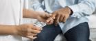 A person is having their blood sugar checked by a health professional.