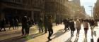 People walking down Buchanan Street in Glasgow. The low sun is creating long shadows on the street.