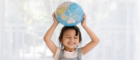 Smiling girl holds a globe above her head