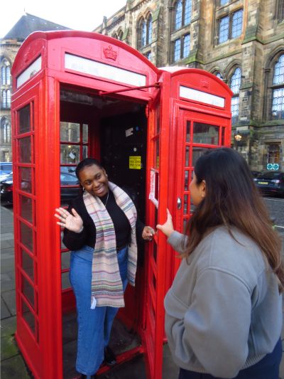 A student greeting another student from the telephone boxes on campus