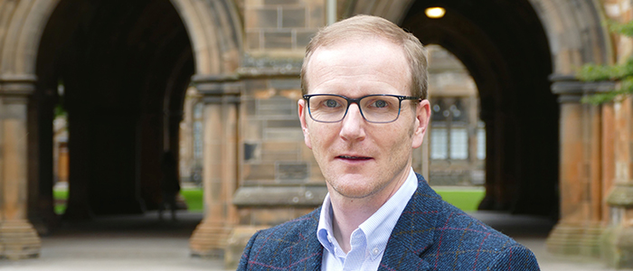 Professor Graeme Roy standing in the west quadrangle at the University of Glasgow