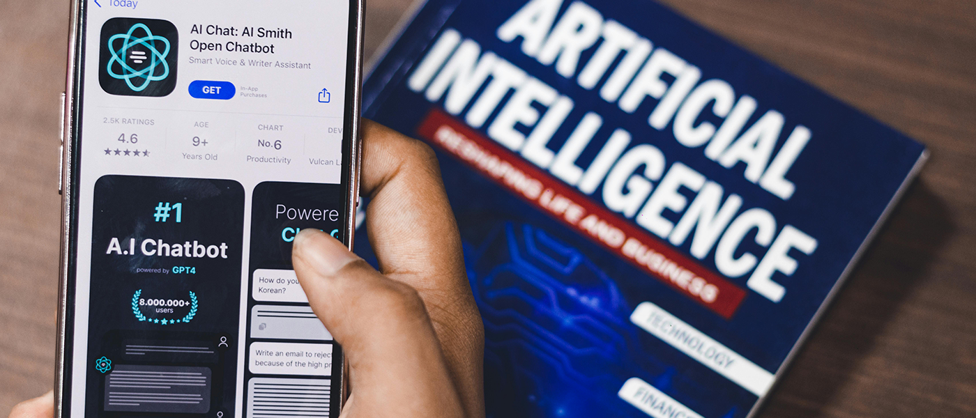 A phone with a GPT app on it beside a book tilted