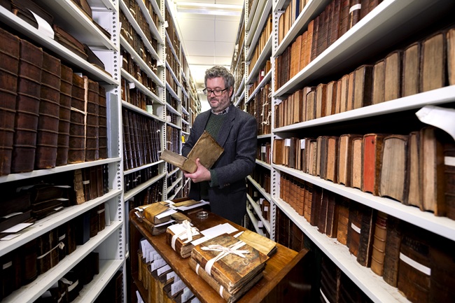 Professor Adrian Streete looking at a book from the personal library of Zachary Boyd. Credit Martin Shields. Professor Adrian Streete looking at a book from the personal library of Zachary Boyd held in the University’s Archives & Special Collections. Credit Martin Shields.