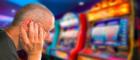 A man looks defeated at a slot machine
