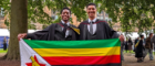 Ryan and Dylan standing in the east quad with the Zimbabwean flag on their graduation day