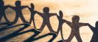 Human chain paper with light and shadow on wood table. 700 pixels