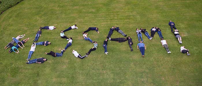 Aerial photo of students spelling out #ESSAM! with their bodies on grass