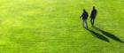 Photo of 2 men walking across grass