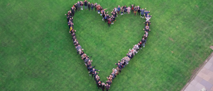 Heart made up of people standing in quad