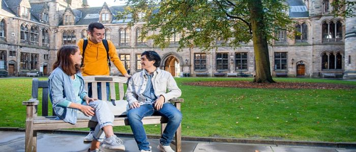 Students sitting on a bench on campus